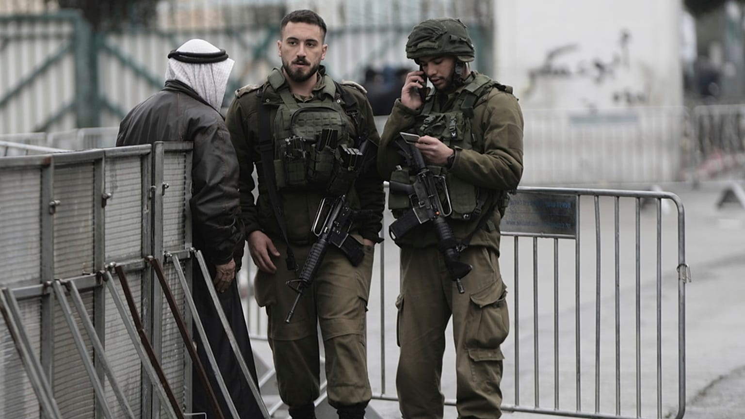 جنود إسرائيليون يدققون في هوية فلسطيني عند حاجز في بيت لحم خلال توجهه إلى الأقصى لصلاة الجمعة الأولى من رمضان، 7 آذار/مارس 2025.