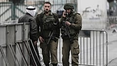 جنود إسرائيليون يدققون في هوية فلسطيني عند حاجز في بيت لحم خلال توجهه إلى الأقصى لصلاة الجمعة الأولى من رمضان، 7 آذار/مارس 2025.