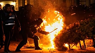 Polis, 9 Mart 2025'te Romanya'nın Bükreş kentinde, Calin Georgescu'nun seçim yeniden oylamasındaki adaylığının reddedilmesinin ardından destekçilerinin protesto gösterisi sırasında bir yangını söndürmeye çalıştı.