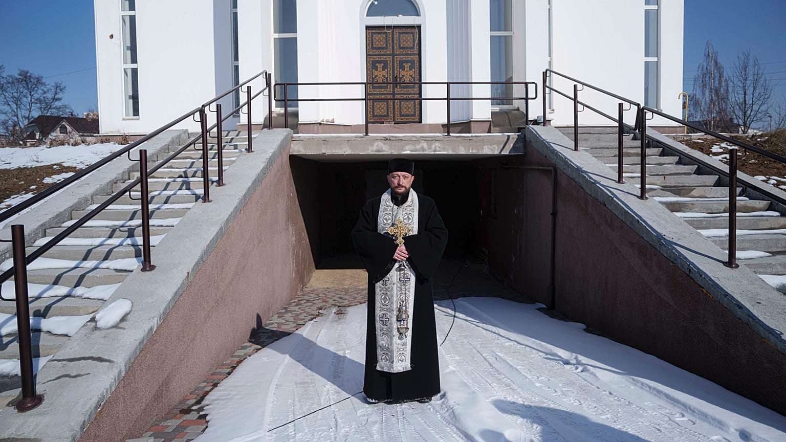 El sacerdote ortodoxo Andrii junto a su iglesia durante una ceremonia conmemorativa del tercer aniversario de la invasión rusa de Ucrania, en Bucha, Ucrania.