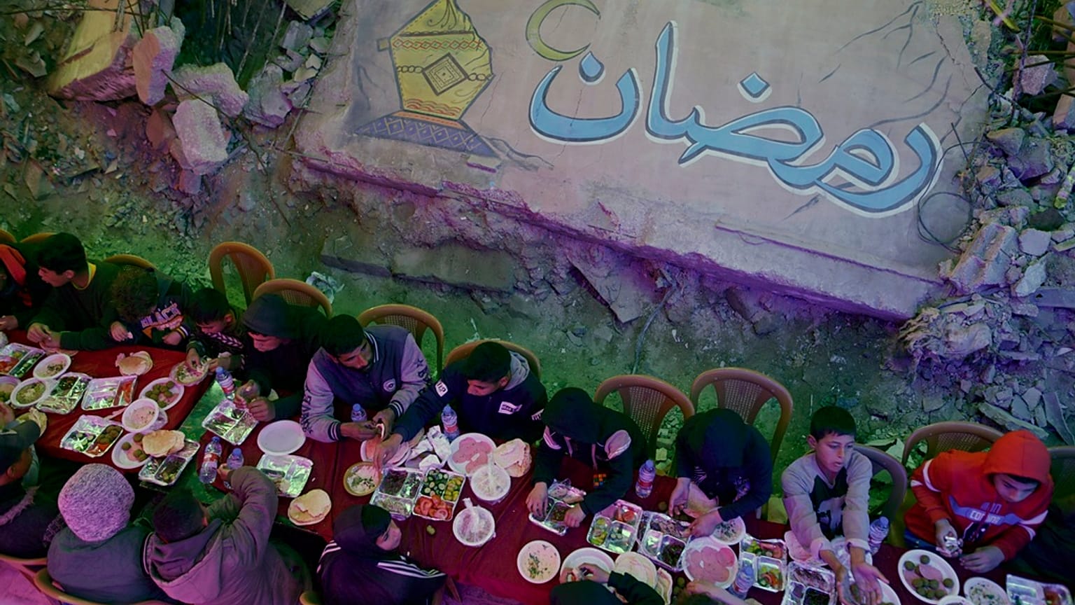 الفلسطينيون يقيمون وجبة سحور جماعية بجانب منازلهم المدمرة خلال شهر رمضان المبارك في خان يونس، جنوب قطاع غزة.