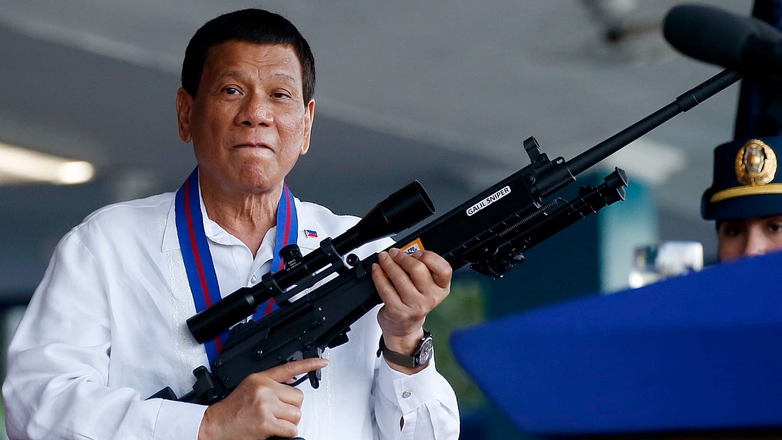 FILE: Philippine President Rodrigo Duterte jokes to photographers as he holds a rifle at Camp Crame northeast of Manila, 19 April 2018