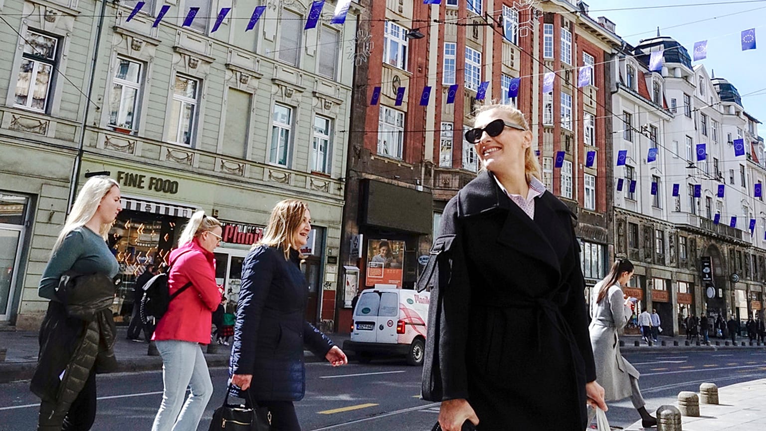 A woman walks under EU flags placed in one of the main streets in Sarajevo, Bosnia, Thursday, March 21, 2024. 