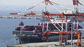 Tokyo yakınlarındaki Kawasaki limanında bulunan bir konteyner terminalinde bir konteyner gemisi yükleniyor ve boşaltılıyor. 9 Mart 2022.