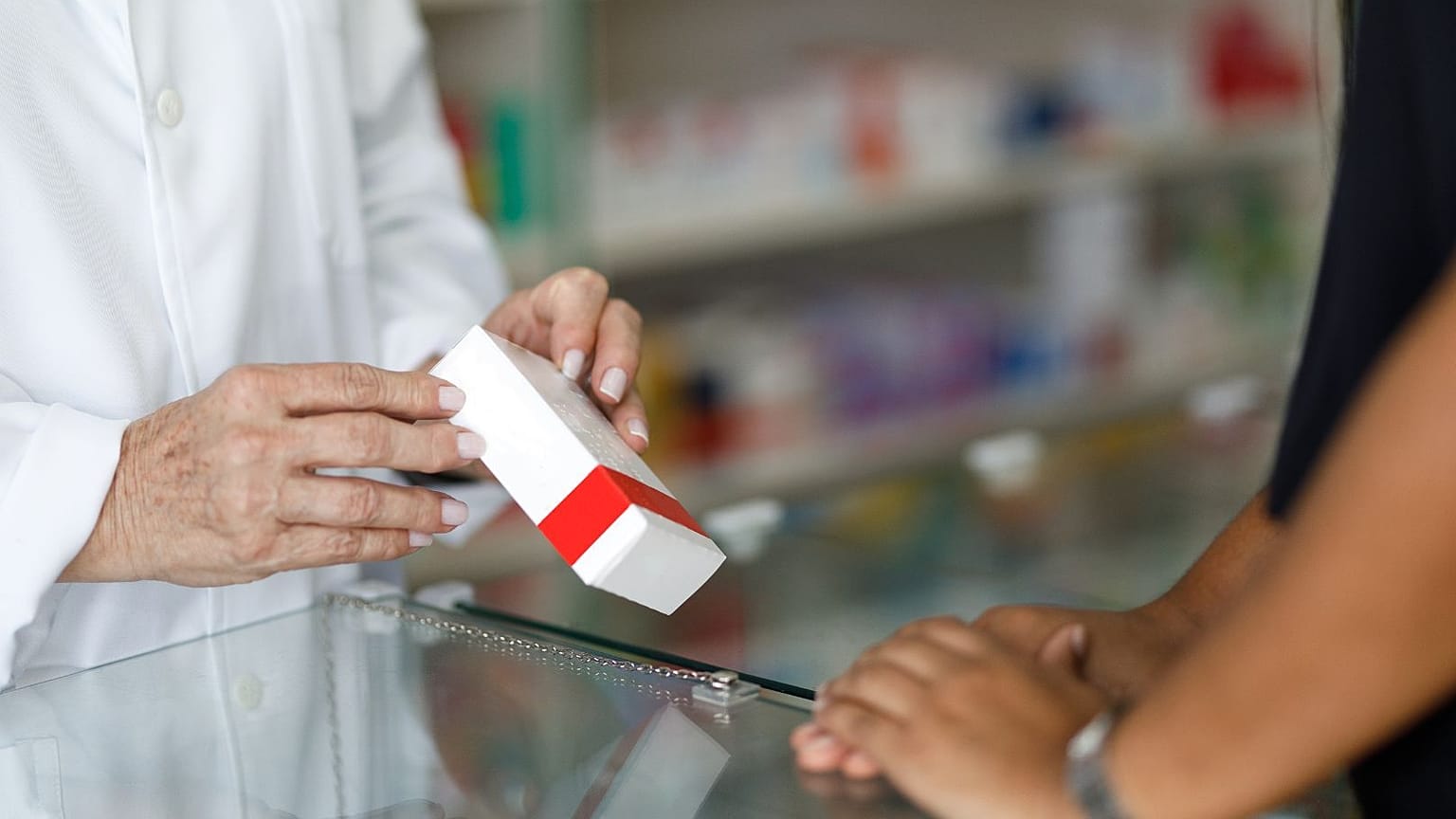 Un pharmacien donne son traitement à un patient.
