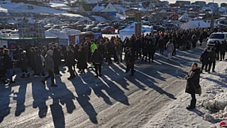 People stand in line outside a polling station to cast their vote in parliamentary elections, in Nuuk, Greenland, Tuesday, March 11, 2025.