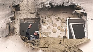 A investigator looks at the damage of an apartment building where a downed Ukrainian drone fell in Sapronovo village outside Moscow, Russia, on Tuesday, March 11, 2025.