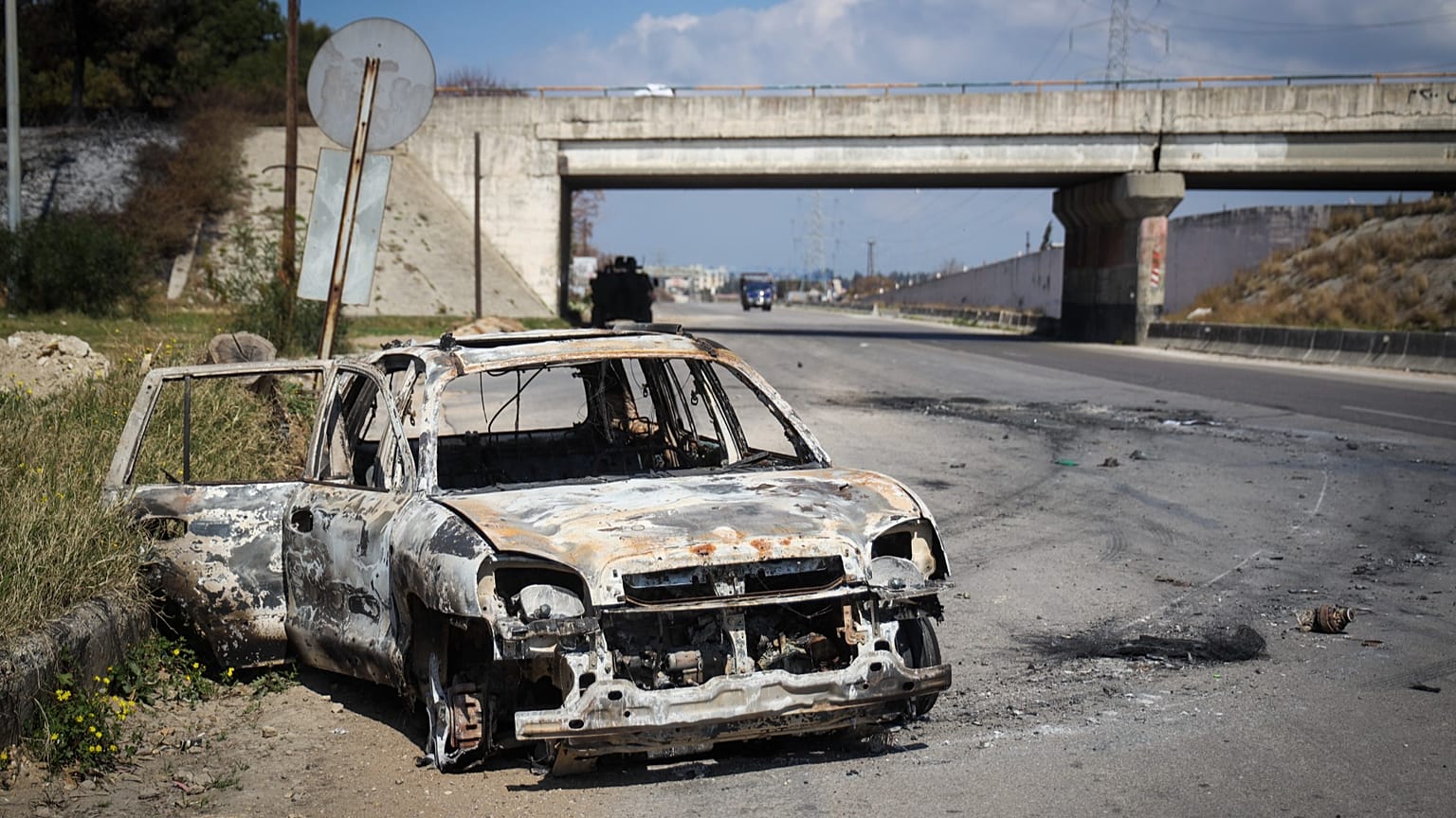 Un'auto bruciata rimane in mezzo a una strada vuota dopo la recente ondata di violenze tra le forze di sicurezza siriane e i lealisti di al-Assad, vicino a Qardaha, 10 marzo 2025