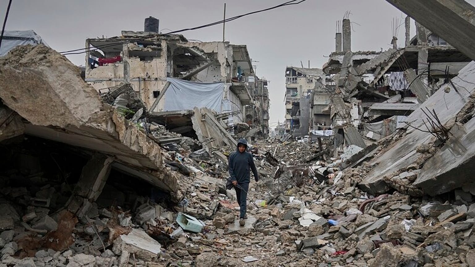 Bir çocuk, 7 Mart 2025 Cuma günü Gazze Şeridi'nin kuzeyindeki Cebaliye'de yıkılan ev ve binaların molozlarıyla kaplı bir sokakta yürüyor