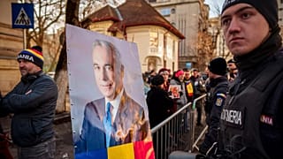 Un retrato de Calin Georgescu, es colocado en una valla antidisturbios por simpatizantes que esperan su llegada a un tribunal de distrito en Bucarest, 5 de marzo de 2025.