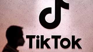 ARQUIVO - Um visitante passa pelos stands de exposição do TikTok na feira de jogos de computador Gamescom em Colónia, Alemanha, quinta-feira, 25 de agosto de 2022.