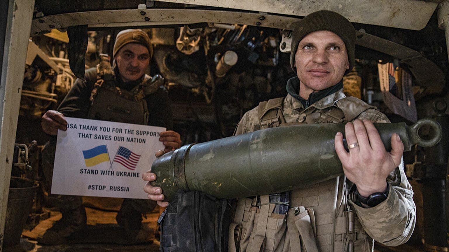 Soldados da 5.ª brigada da Ucrânia seguram um cartaz a agradecer o apoio dos EUA durante um flashmob na linha da frente perto de Toretsk, região de Donetsk, Ucrânia, 11 de março de 2025.