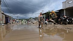DATEIFOTO - Eine Frau geht am Montag, dem 5. Juni 2023, auf einer überfluteten Straße in Esmeraldas, Ecuador.