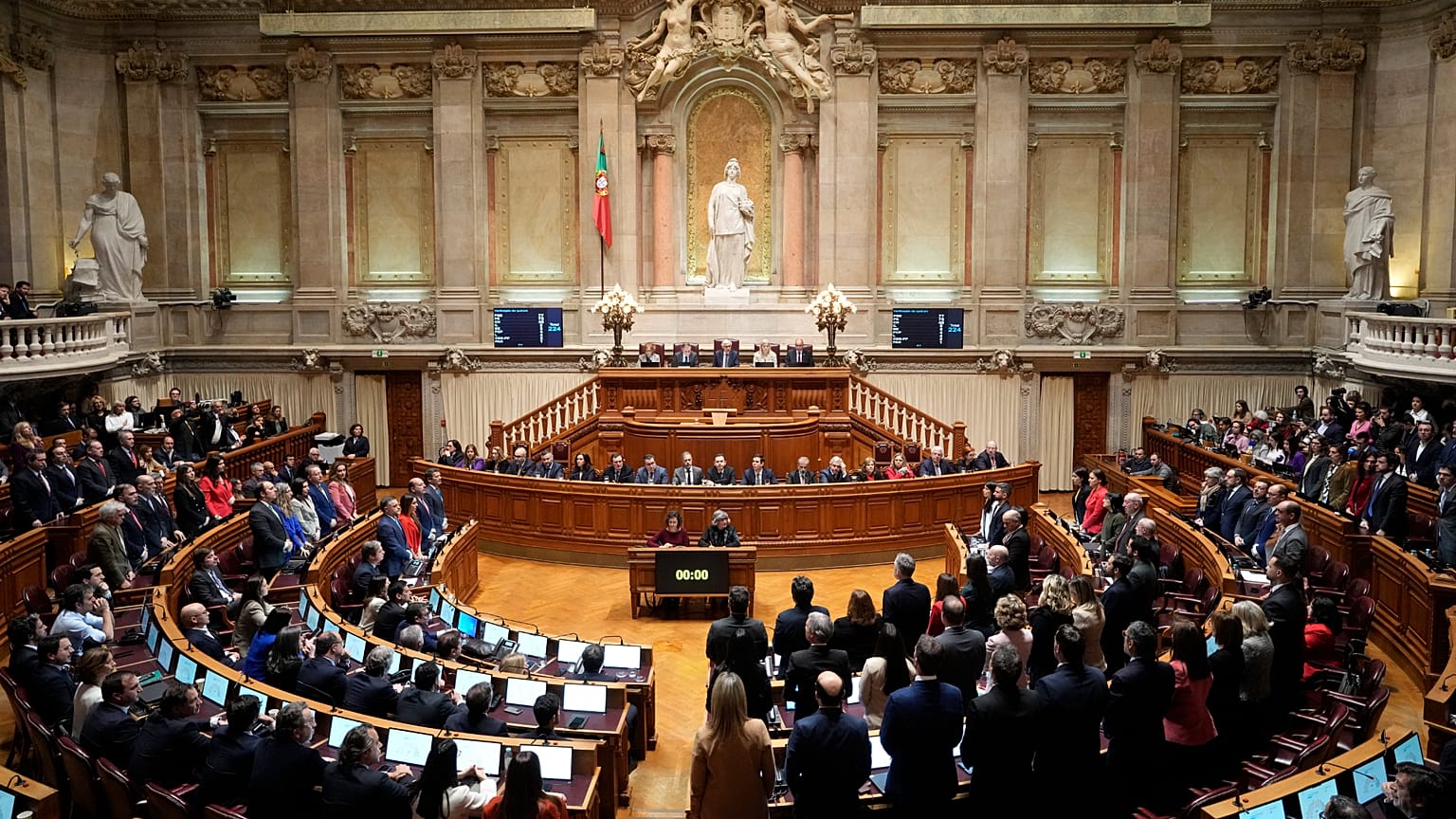 Members of opposition parties stand to vote against a government confidence motion at the Portuguese parliament in Lisbon, 11 March, 2025