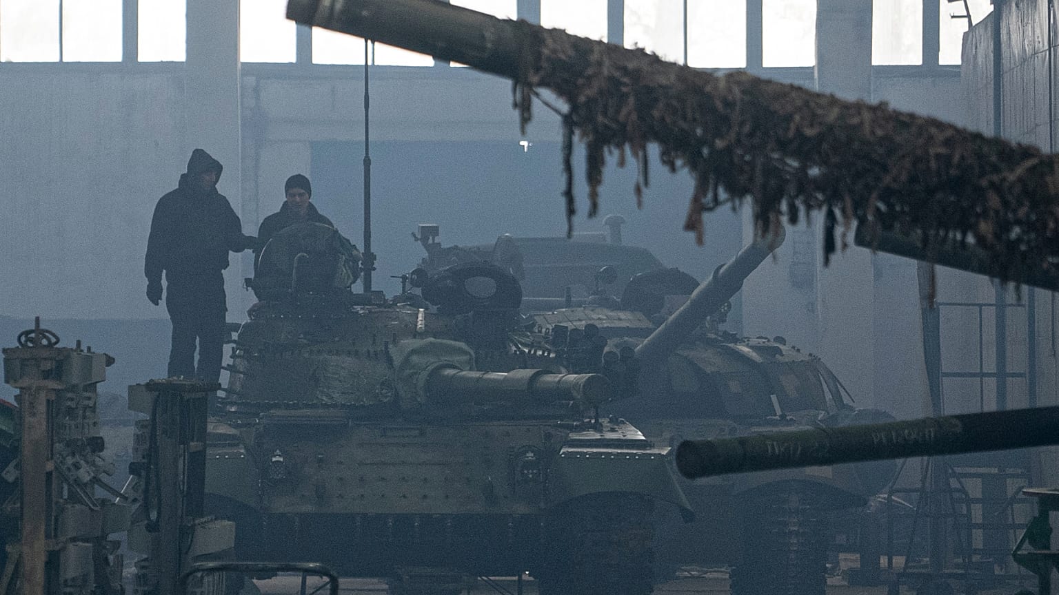 İşçiler Ukrayna'nın Kharkiv kentindeki Onarım Tankı Fabrikasında bir T-64 tankının üzerinde duruyor.
