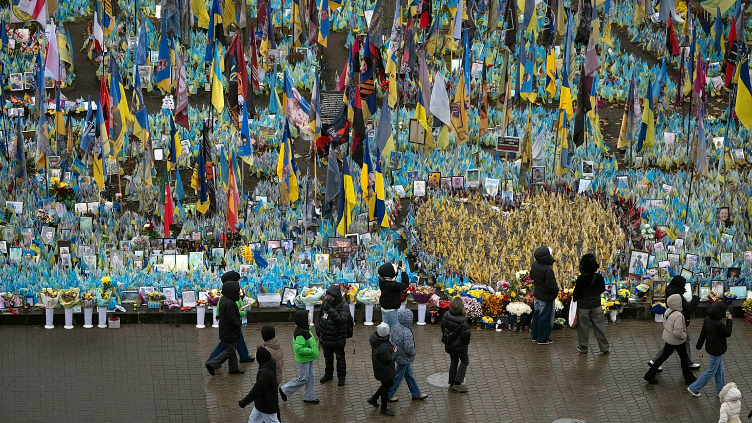 Des gens passent devant le mémorial aux soldats tombés au combat sur la place de l'Indépendance à Kyiv, en Ukraine, le vendredi 15 novembre 2024.
