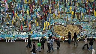 Des gens passent devant le mémorial aux soldats tombés au combat sur la place de l'Indépendance à Kyiv, en Ukraine, le vendredi 15 novembre 2024.