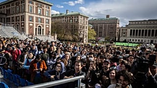 Studenti e stampa guardano il presidente della Camera Mike Johnson (R-LA) mentre parla ai media alla Columbia University, New York, il 24 aprile 2024.