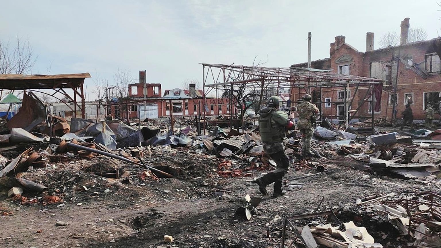 Russische Soldaten spazieren zwischen den Ruinen von Sudzha, der größten Stadt in der russischen Region Kursk, nachdem sie von russischen Truppen eingenommen wurde, Donnerstag, 13. März 2025