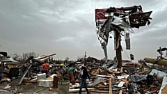 Menschen arbeiten sich am Samstag, den 15. März 2025, nach einem schweren Unwetter durch die Trümmer des Cave City Auto Parts Store
