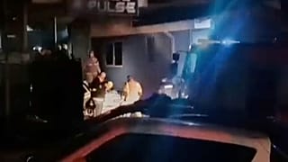 Des secouristes se tiennent devant un club après qu'un gigantesque incendie se soit déclaré tôt dimanche à Kočani, en Macédoine du Nord, le 16 mars 2025.
