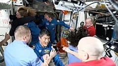 Astronaut Takuya Onishi, Mitte, begrüßt sich nach dem Andocken der SpaceX-Kapsel an die Internationale Raumstation, 16. März 2025