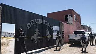 La policía hace guardia en la entrada del Rancho Izaguirre, donde se descubrieron restos óseos en Teuchitlán, estado de Jalisco, México.
