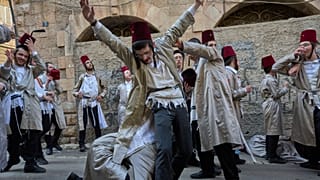 Des hommes juifs ultra-orthodoxes célèbrent la fête juive de Pourim à Mea Shearim, un quartier ultra-orthodoxe de Jérusalem, dimanche 16 mars 2025.