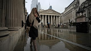 Μια γυναίκα περπατά μπροστά από την Τράπεζα της Αγγλίας, στην οικονομική περιοχή του Λονδίνου. 13 Μαρτίου 2025.