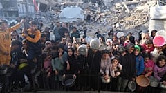 Palästinenser warten auf gespendete Lebensmittel in einem Verteilungszentrum in Beit Lahiya, im nördlichen Gazastreifen, Sonntag, 16. März 2025.