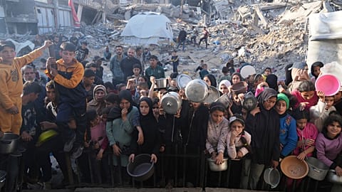 Des Palestiniens attendent de recevoir de la nourriture donnée dans un centre de distribution à Beit Lahiya, dans le nord de la bande de Gaza, dimanche 16 mars 2025.