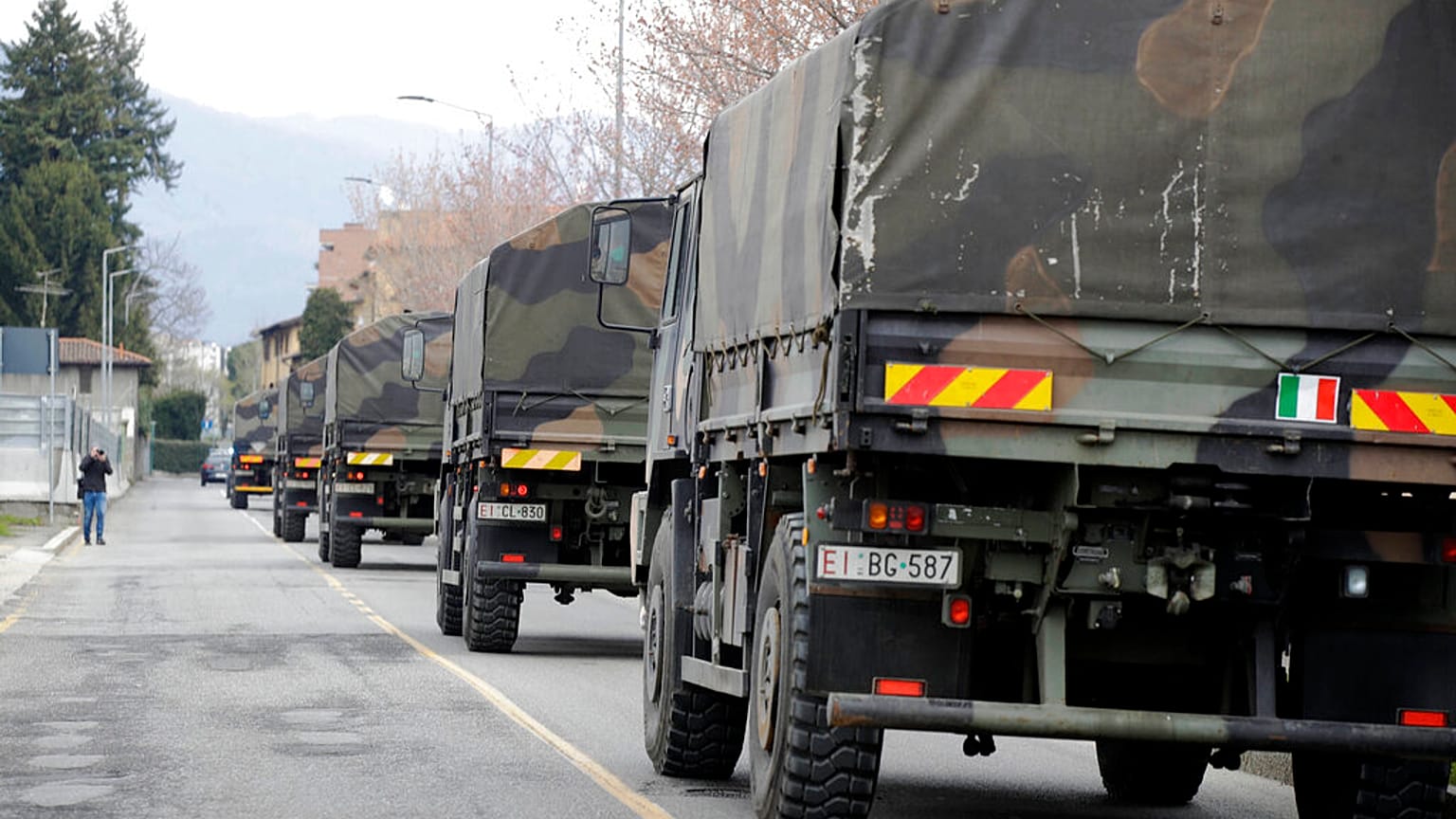 In this March 26, 2020 file photo, military trucks moving coffins of deceased people leave the cemetery of Bergamo