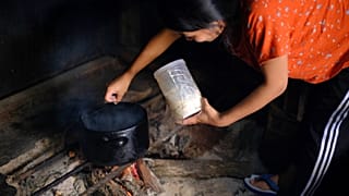 A woman cooks on an open fire in Kohima, India, on Thursday, Oct. 10, 2024.