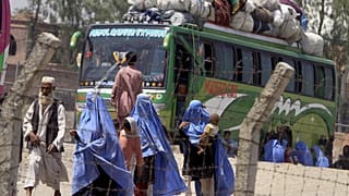 Una famiglia afghana cammina verso il proprio autobus per partire per l'Afghanistan al terminal dell'UNHCR per i rimpatri a Peshawar, in Pakistan, il 24 maggio 2009.