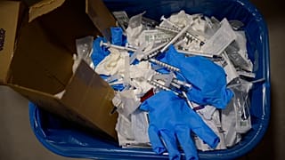 Foto de archivo de una papelera con jeringuillas y guantes después de que los residentes recibieran una dosis de la vacuna contra el COVID-19 en Estella, Navarra.