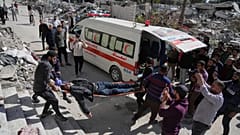 Palästinenser evakuieren einen verletzten Mann, nachdem sein Haus von einem israelischen Bombardement in Gaza-Stadt getroffen wurde, 19. März, 2025