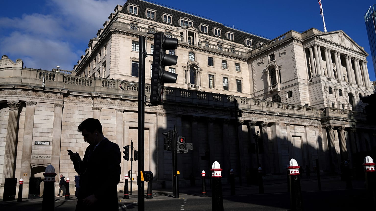 Bir adam, 6 Şubat 2025 Perşembe günü Londra'daki İngiltere Merkez Bankası önünde telefonuna bakarken siluet halinde görülüyor.