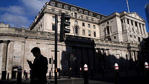 A man is silhouetted as he looks on his phone in front of the Bank of England in London, Thursday, Feb. 6, 2025.