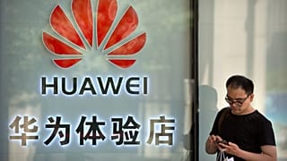 In questa foto di archivio del 29 maggio 2019, un uomo usa il suo smartphone fuori da un negozio che vende prodotti Huawei in un centro commerciale di Pechino.