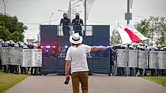 Der Künstler Ales Pushkin schwenkt eine rot-weiße Flagge, die die oppositionelle Lukaschanka symbolisiert, vor einer Polizeisperre während einer Demonstration in Minsk, Belarus 23.08.2020