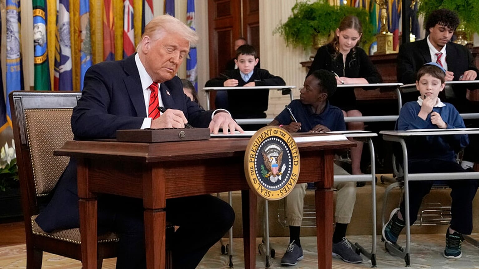 Donald Trump elnök aláír egy végrehajtási rendeletet a washingtoni Fehér Ház keleti termében 2025. március 20-án, csütörtökön.