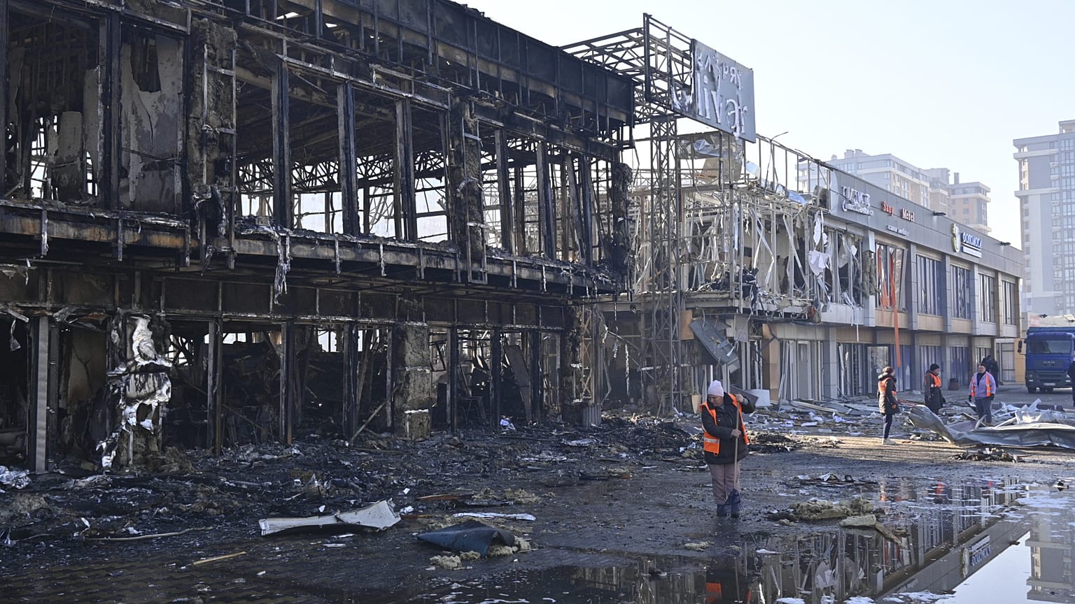 Municipal workers clean up after Russian drones hit shops during a night attack in Odesa, 21 March, 2025