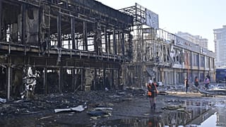 Municipal workers clean up after Russian drones hit shops during a night attack in Odesa, 21 March, 2025