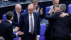 Der CDU-Parteivorsitzende Friedrich Merz, Mitte, reagiert nach einer Debatte und Abstimmung über die Lockerung der Schuldenregeln in Berlin, Deutschland, Dienstag, 2025.