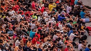 Unaccompanied minors who crossed into Spain are gathered outside a warehouse used as temporary shelter at the Spanish enclave of Ceuta, 19 May, 2021