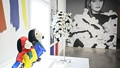 Figuritas que representan a Snoopy lucen creaciones como parte del 75 aniversario de Peanuts, en la exposición Snoopy In Style.