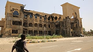 Un soldat marche devant le palais républicain de Khartoum après sa prise par l'armée soudanaise, 21 mars 2025.