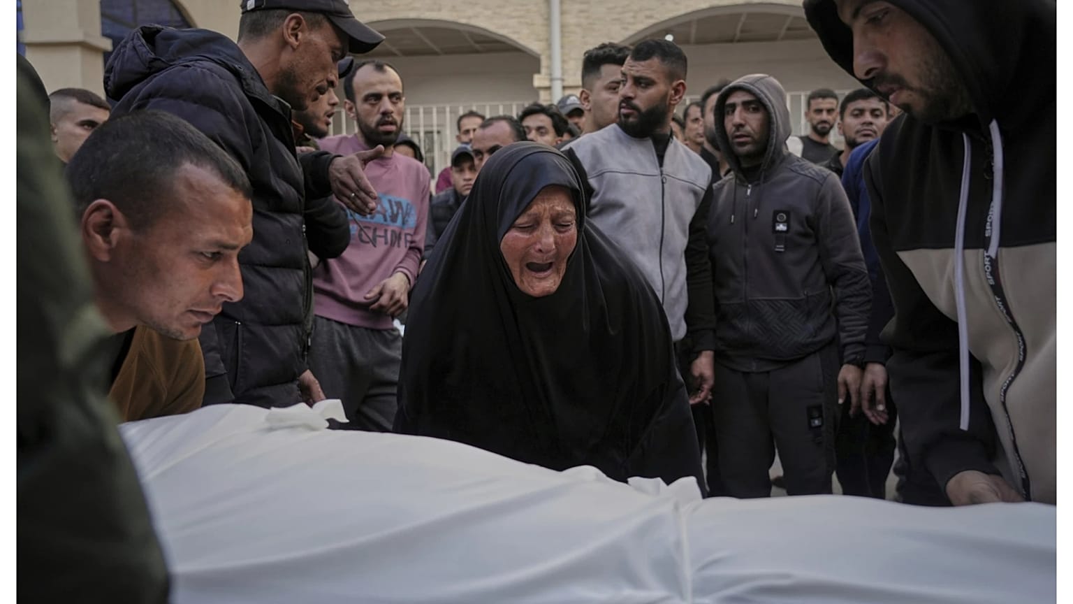 امرأة تبكي فوق جثمان أحد الضحايا الذين قُتلوا خلال غارات جوية شنها الجيش الإسرائيلي على قطاع غزة، في مستشفى الأهلي بمدينة غزة، الثلاثاء 18 مارس 2025