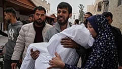 Um homem palestiniano carrega o corpo da sua filha de 11 anos, Aya Al-Samri, que foi morta por um ataque aéreo do exército israelita,