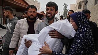 Um homem palestiniano carrega o corpo da sua filha de 11 anos, Aya Al-Samri, que foi morta por um ataque aéreo do exército israelita,